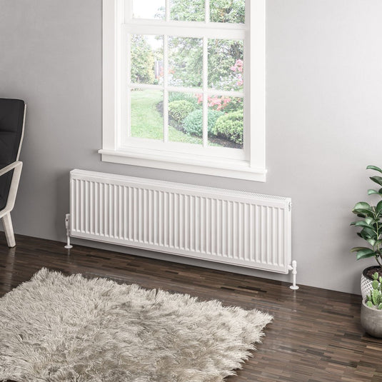 Modern white horizontal radiator under window in contemporary living room with wooden floor
