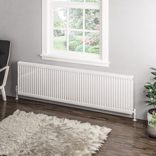 Modern white horizontal panel radiator beneath window in contemporary living room