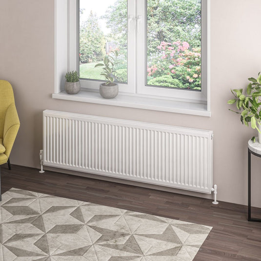 Modern white horizontal radiator under window in stylish living room with plants