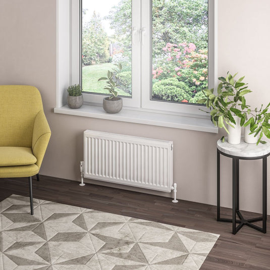 Modern living room with white panel radiator, large window, indoor plants, and yellow armchair