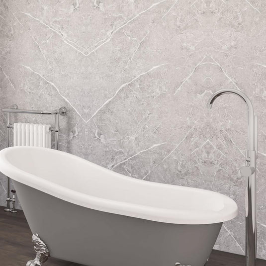 Freestanding grey bathtub with claw feet, chrome floor tap, marble effect bathroom wall