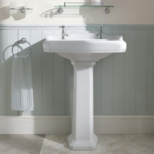 White pedestal basin sink with twin taps in a classic bathroom setting
