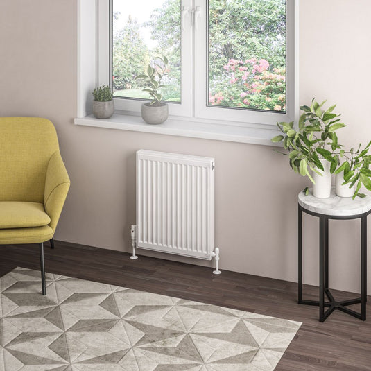 Modern living room with white radiator, large window, yellow armchair, and indoor plants