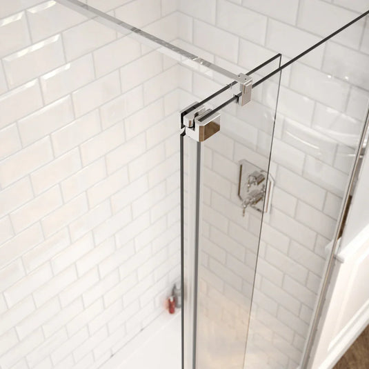 Frameless glass shower enclosure with chrome hardware and white subway tile walls