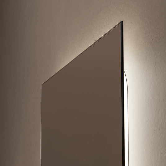 Rectangular bathroom mirror with slim frame and soft ambient backlighting on wall