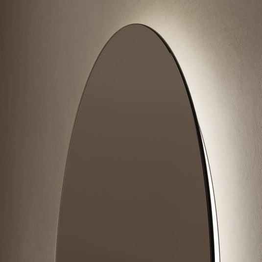 Oval bathroom mirror with backlit LED lighting on a neutral wall